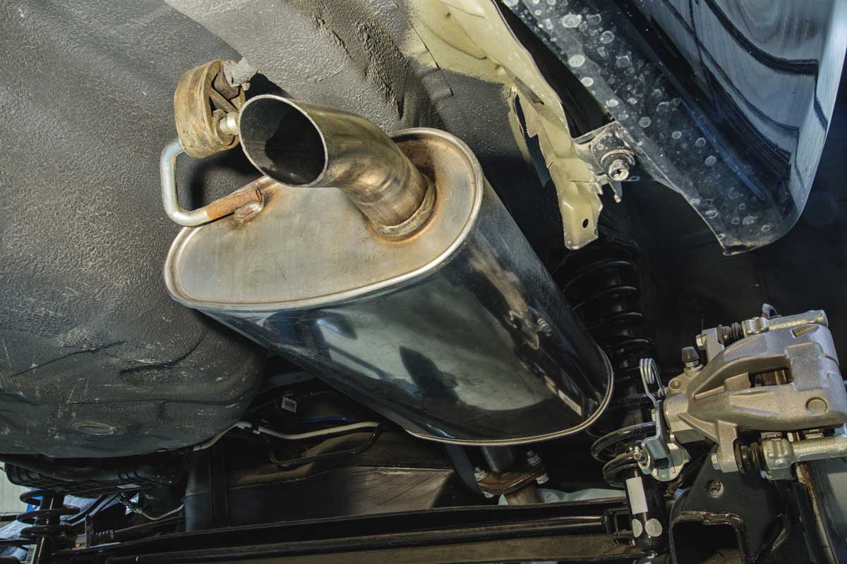 Technician completing muffler repair and exhaust service in Denver, CO